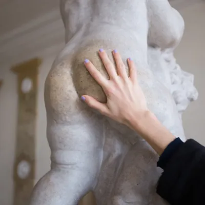 hand caressing the butt of a statue suggesting butt play